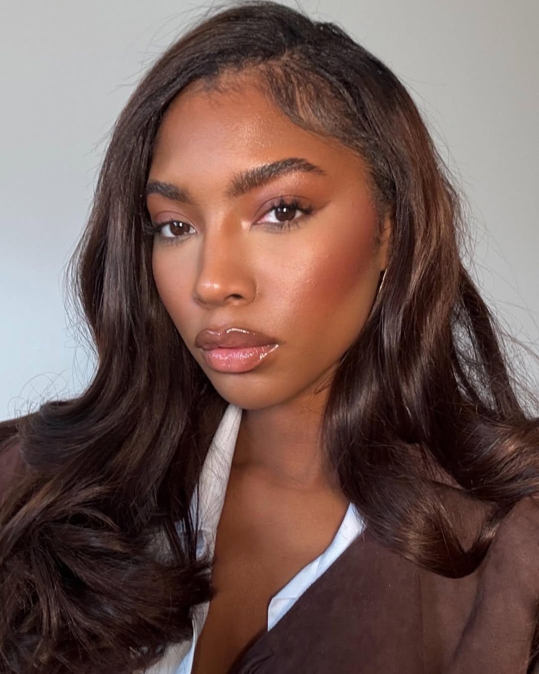 mulher negra usando sombra e maquiagem marrom, um dos itens da necessaire de inverno