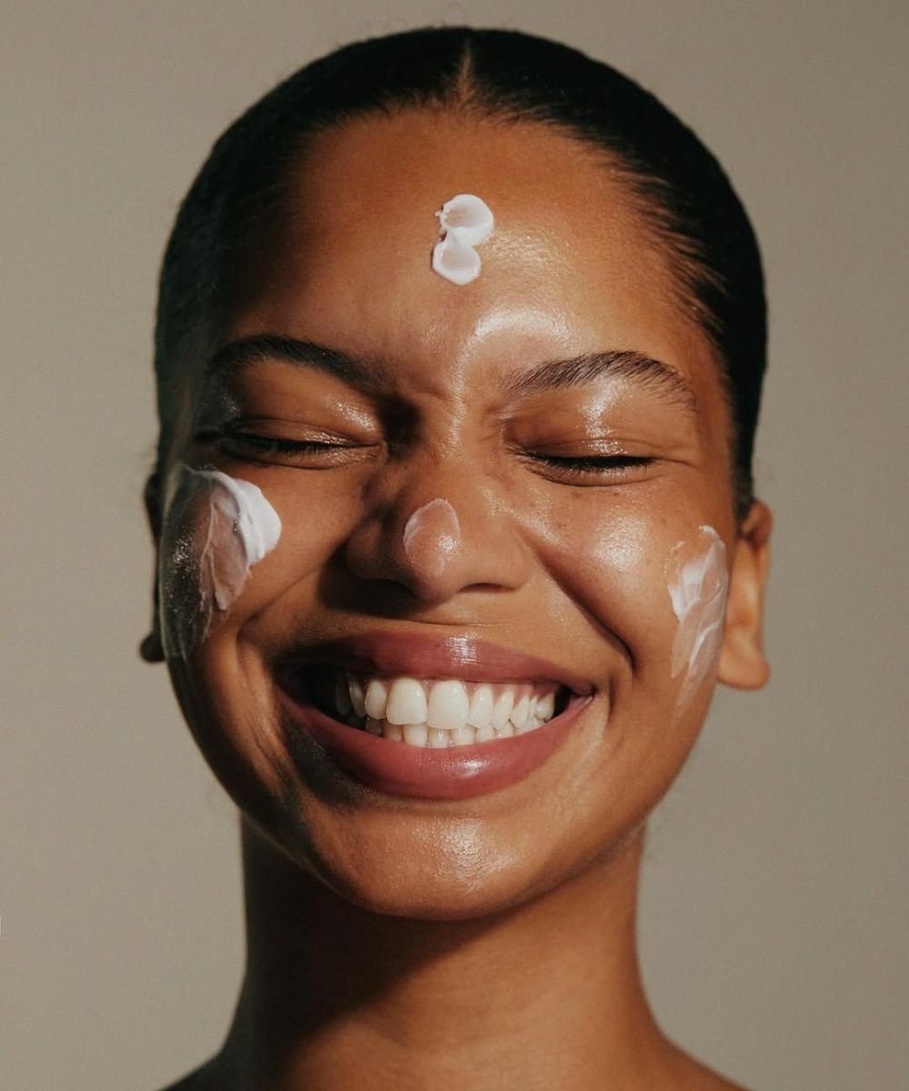 Pele radiante com creme facial aplicado no rosto, destacando cuidados com a pele.