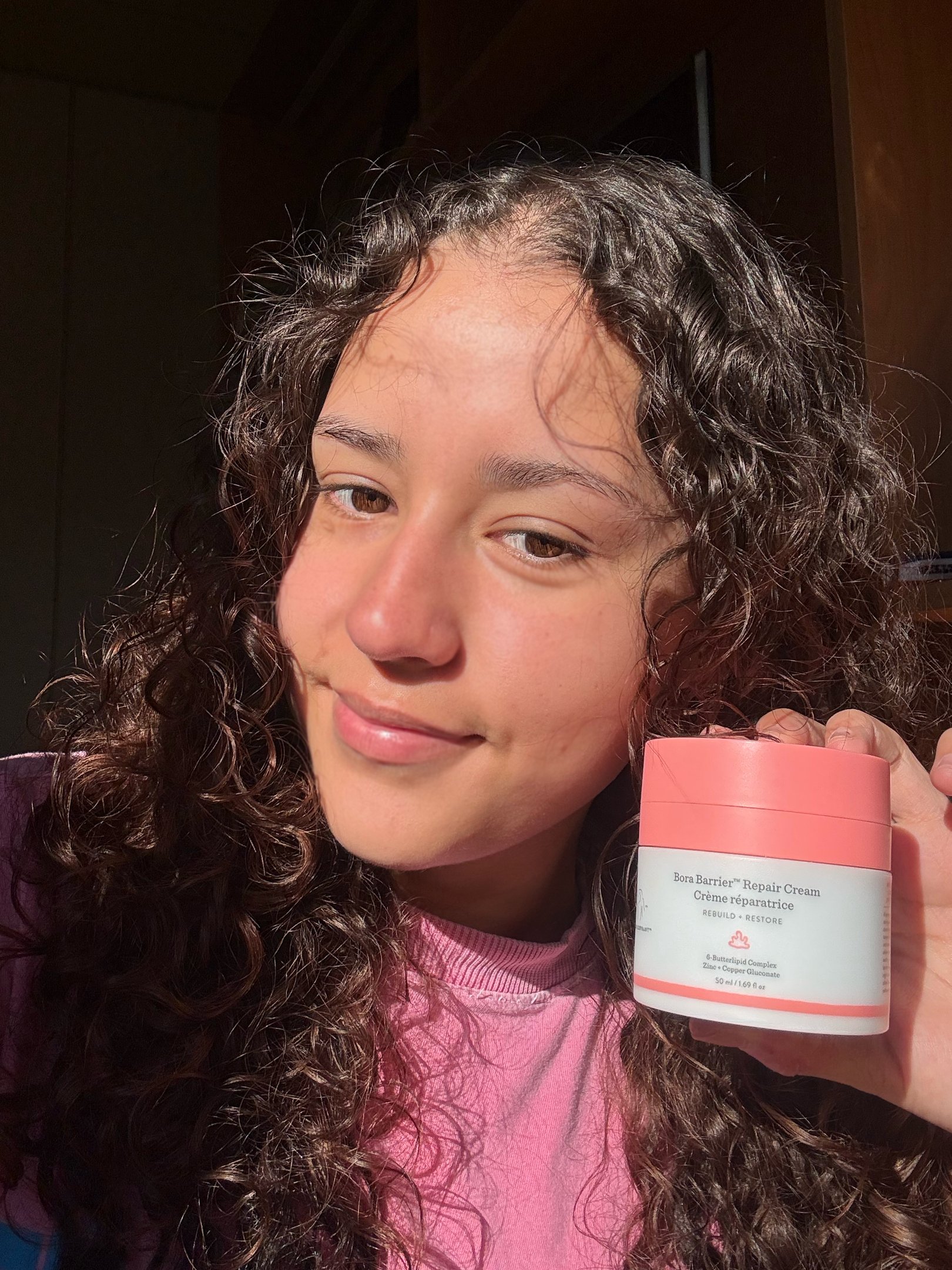 Bora Barrier Repair Cream com tampa rosa parcialmente aberta, mostrando o creme saindo. Embalagem de 50 ml.