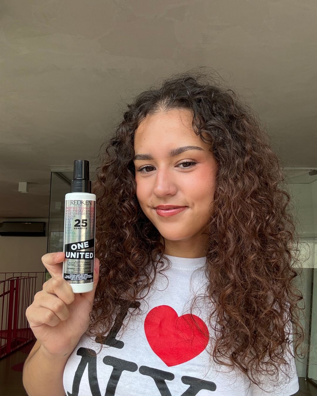 mulher com cabelo cacheado finalizado com leave-in mltibenefícios