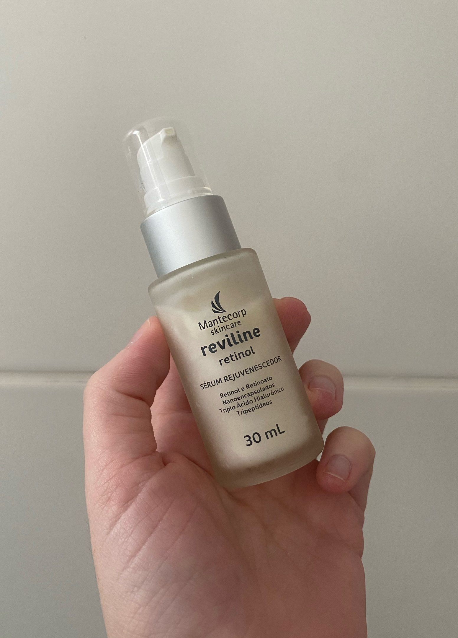 sérum com retinol rejuvenescedor Reviline da Mantecorp em frasco de 30 mL sendo segurado por uma mão.