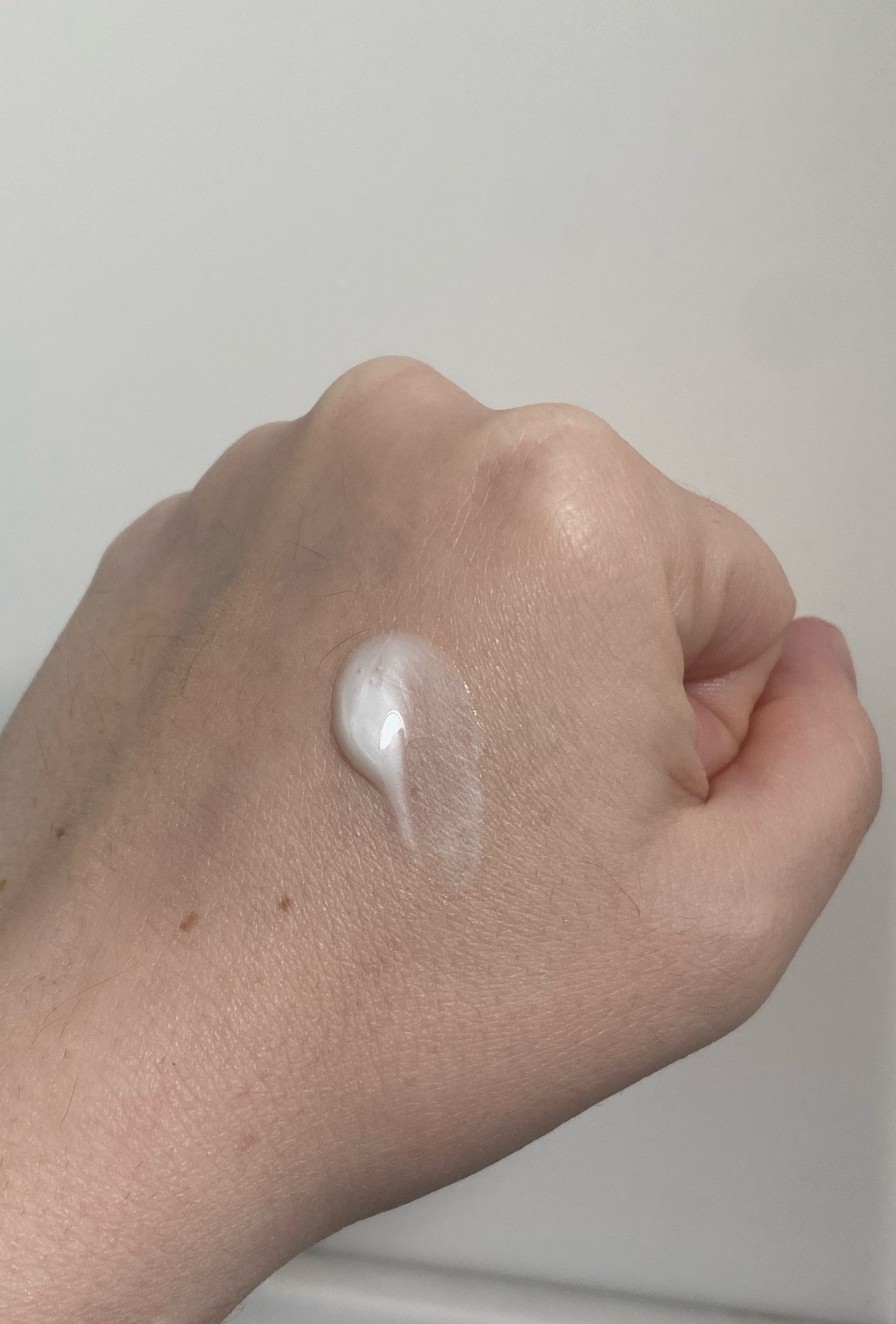 Aplicação de sérum com retinol cremoso sobre a mão.