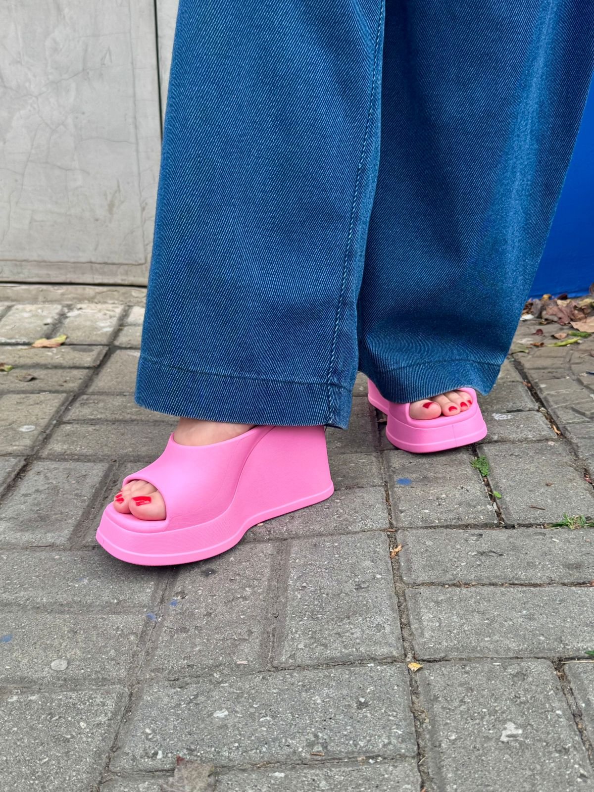 Sandálias plataforma rosa chamativo combinadas com jeans largo, uma das cores de sapato que vão bombar no verão de 2026