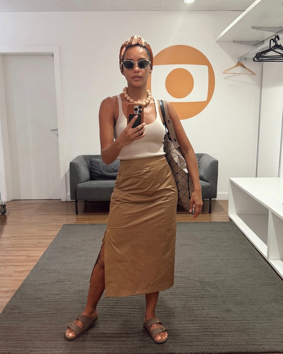 Taís Araújo vestindo roupa casual e óculos de sol em foto no espelho.