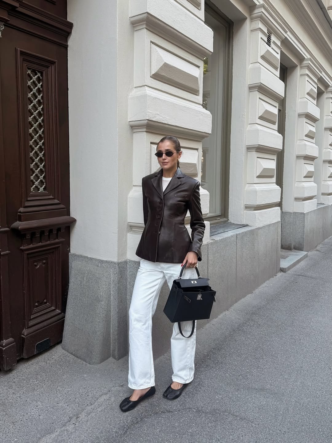 Pessoa com look formal em frente a prédio, possivelmente indo para entrevista de emprego.