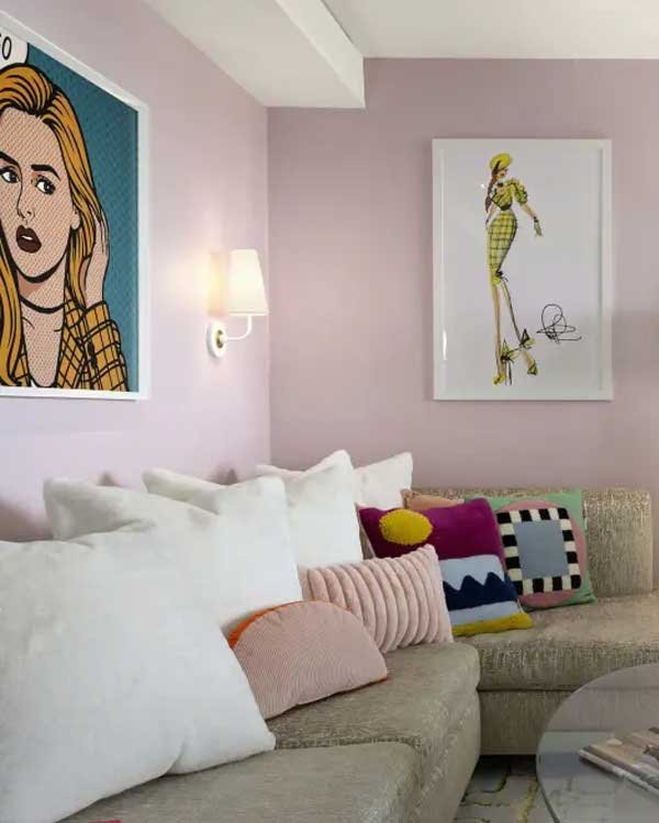 Sala rosa com quadros vibrantes na parede, almofadas coloridas e decoração moderna inspirada na elegância de As Patricinhas de Beverly Hills