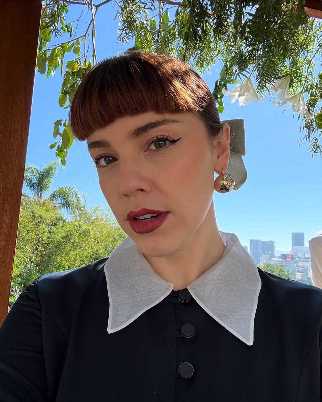 Solange Duprat de batom vermelho com colarinho vintage.