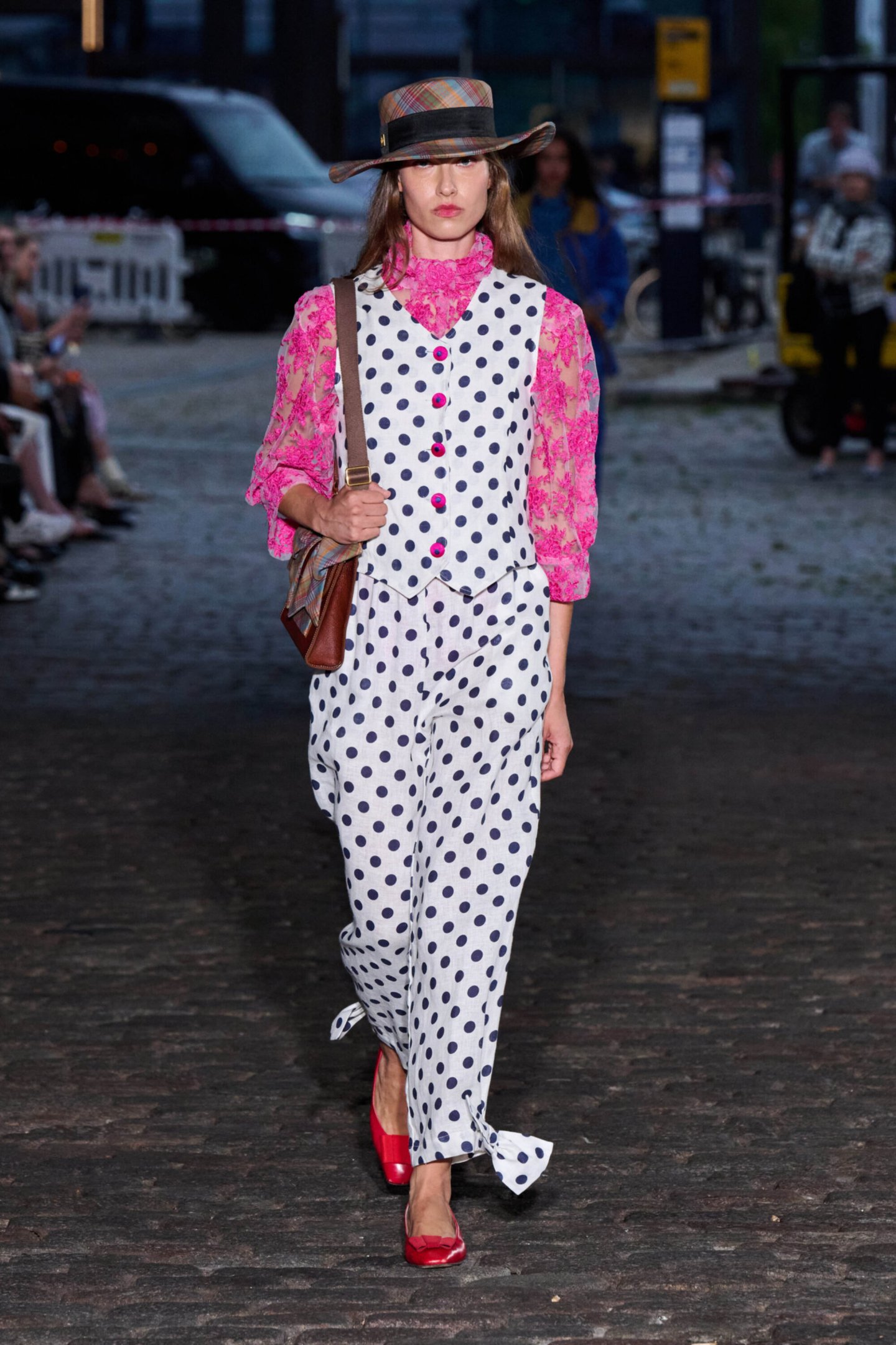 Modelo usa conjunto com bolinhas e blusa rosa, chapéu e sapatos vermelhos. Copenhagen Fashion Week Spring 2026.