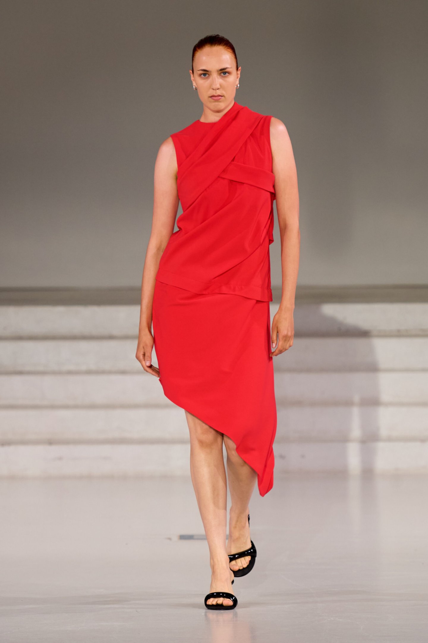 Modelo desfila em vestido vermelho assimétrico na Copenhagen Fashion Week Spring 2026.