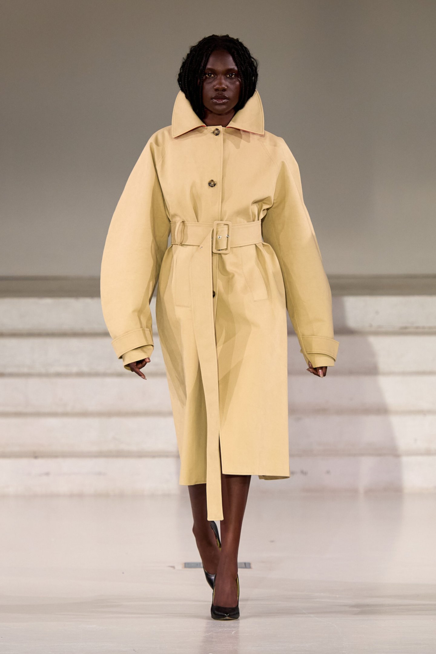 Modelo desfila em casaco bege com cinto, na Copenhagen Fashion Week Spring 2026.