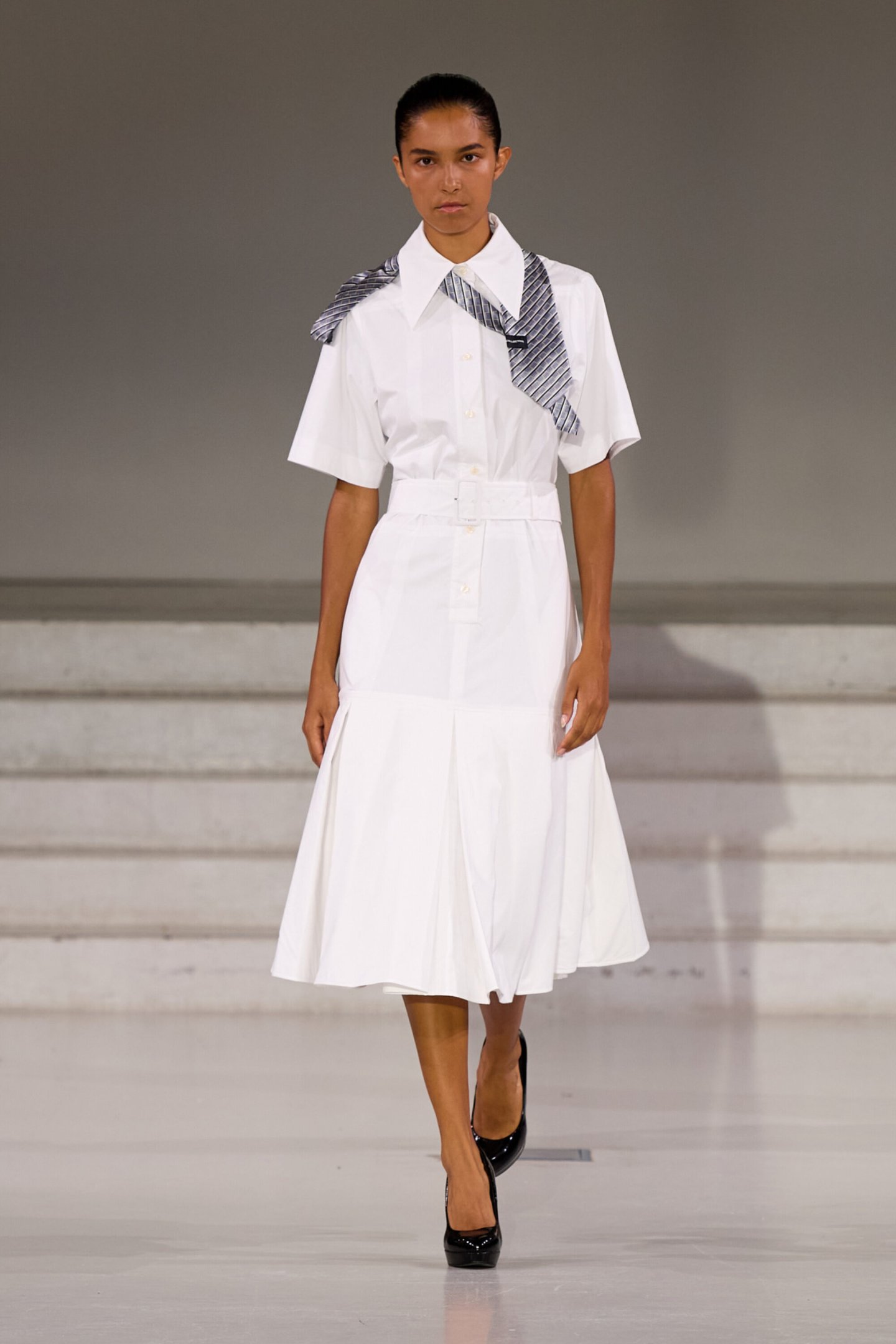 Modelo usa vestido branco elegante com detalhe de gravata na Semana da Moda de Copenhagen Primavera 2026.