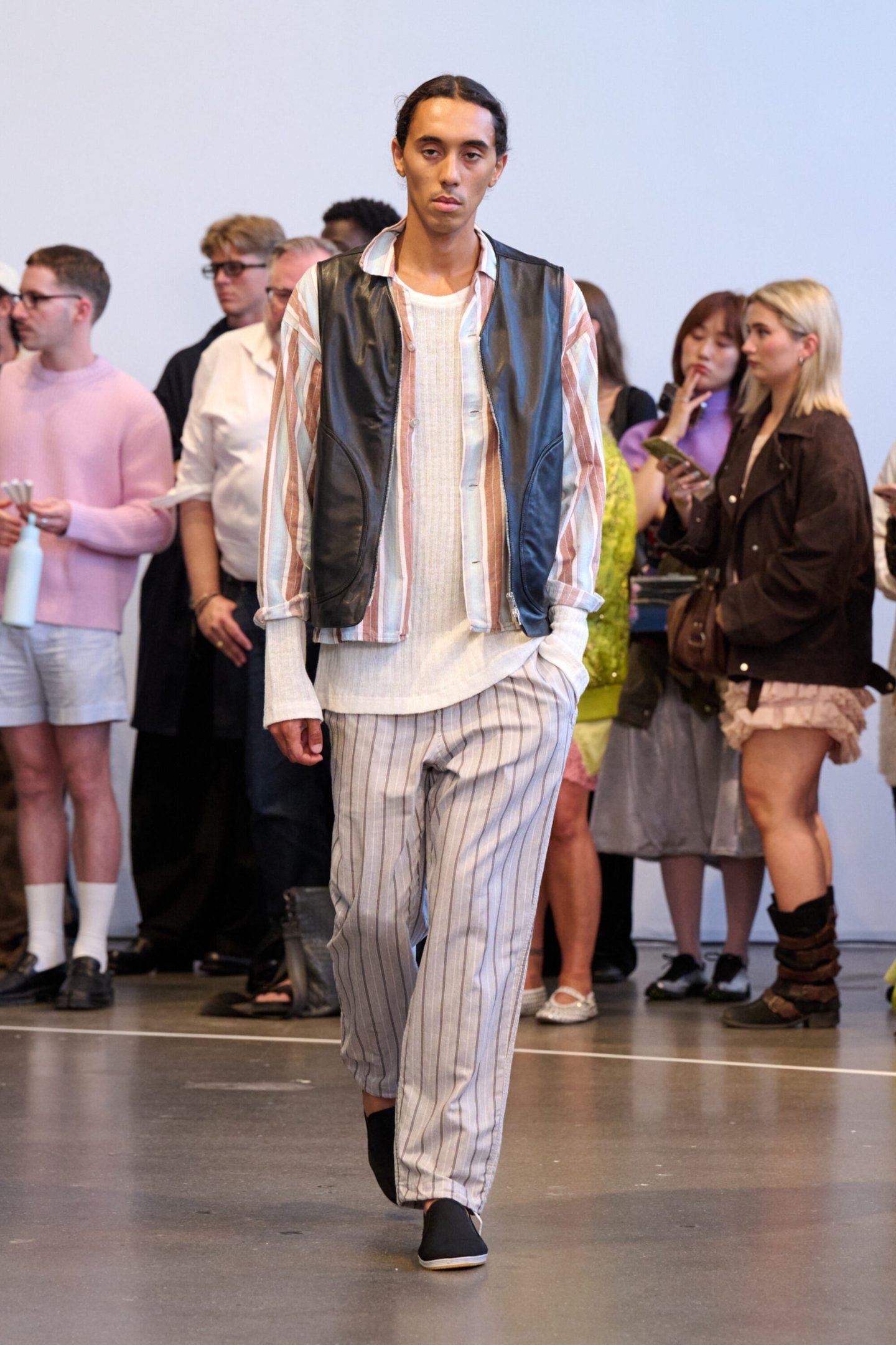 Desfile apresenta modelo com traje listrado e colete de couro, Copenhagen Fashion Week Primavera 2026.
