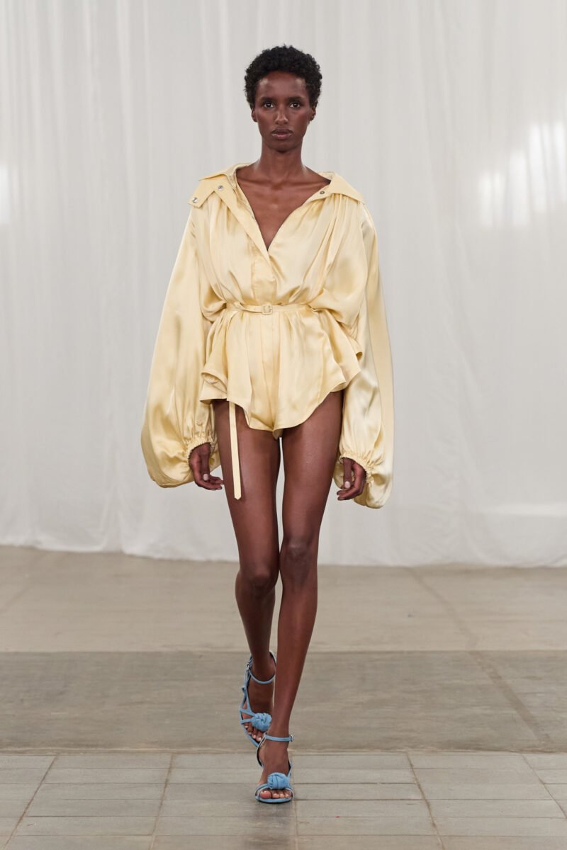Modelo usa roupa amarela fluida com sandálias azuis na Copenhagen Fashion Week Spring 2026.