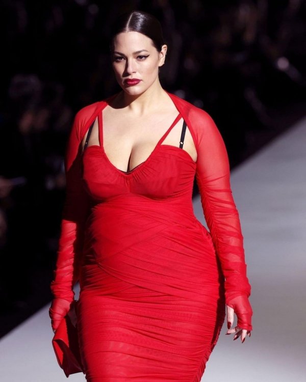 Modelo em passarela usando vestido tomato red elegante com mangas longas.