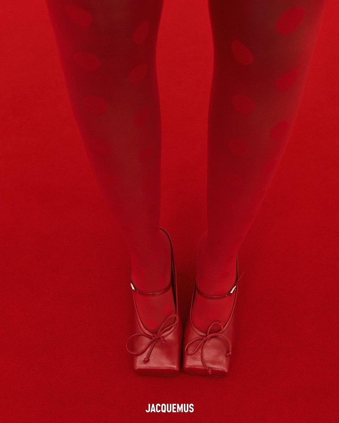 Meias com estampa de bolinhas e sapatos sobre carpete vermelho vivo.
