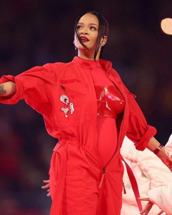 Cantora com macacão vermelho vibrante, em performance no palco.