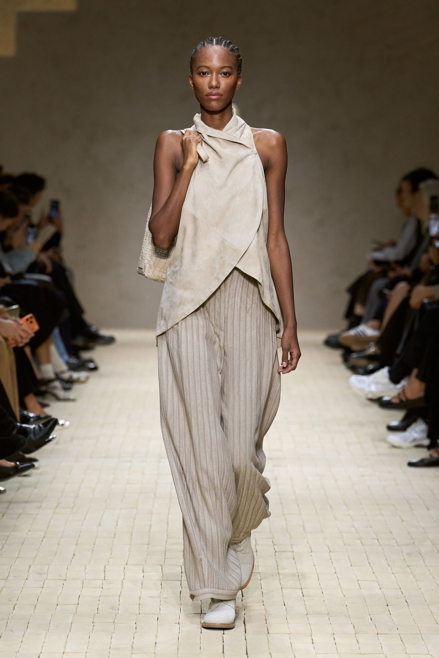 Modelo vestindo conjunto bege de top e calça larguinhos na passarela da Milan Fashion Week SS26.