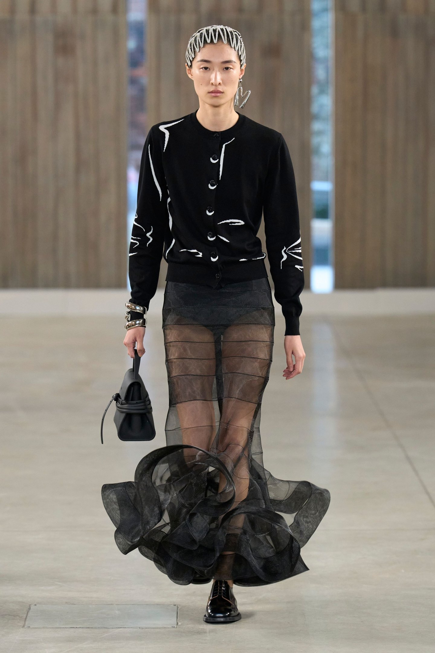 Modelo com suéter preto e saia transparente na passarela da Milan Fashion Week SS26.