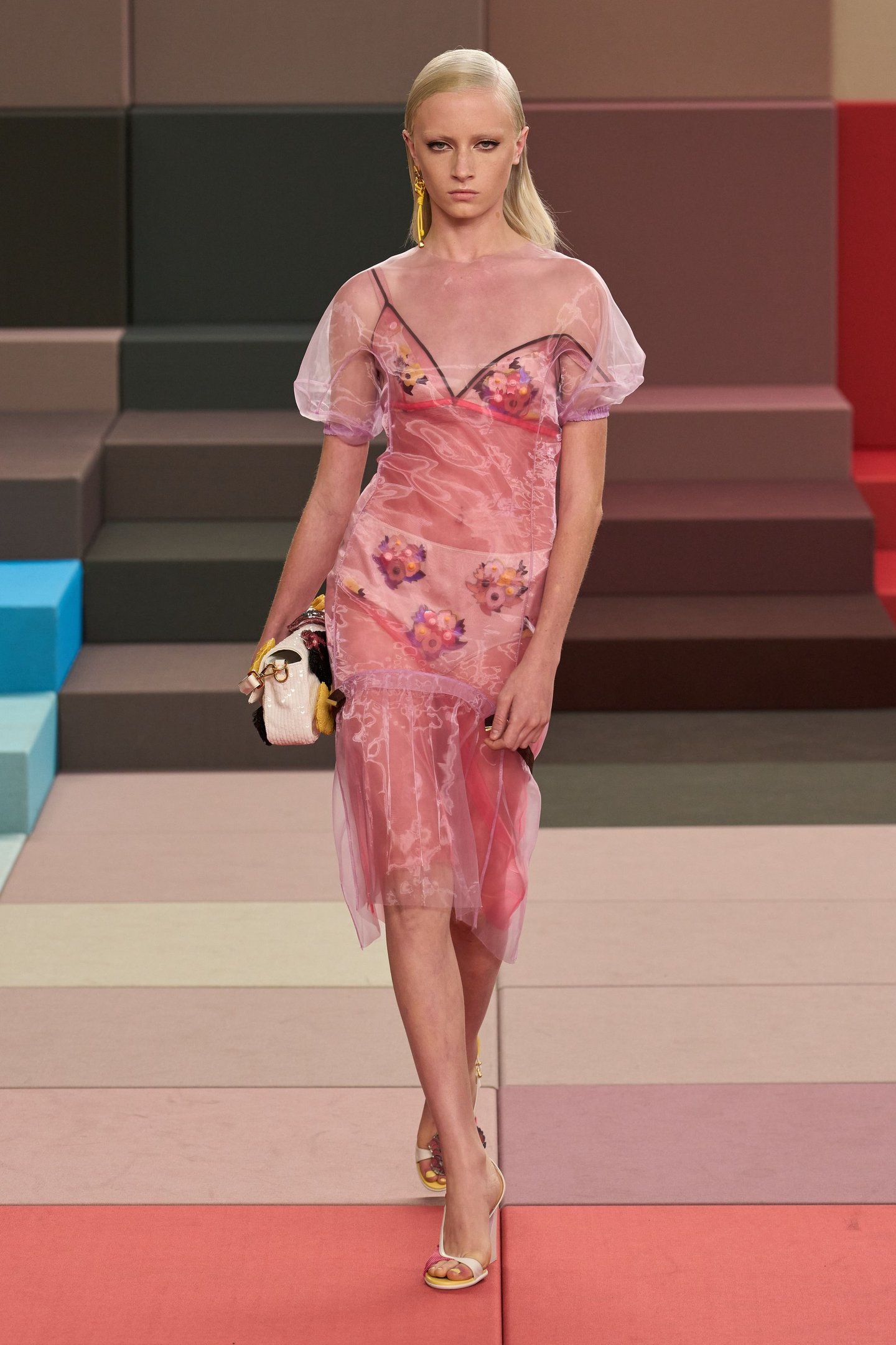 Modelo em vestido rosa transparente com flores, desfilando na Semana de Moda de Milão SS26.