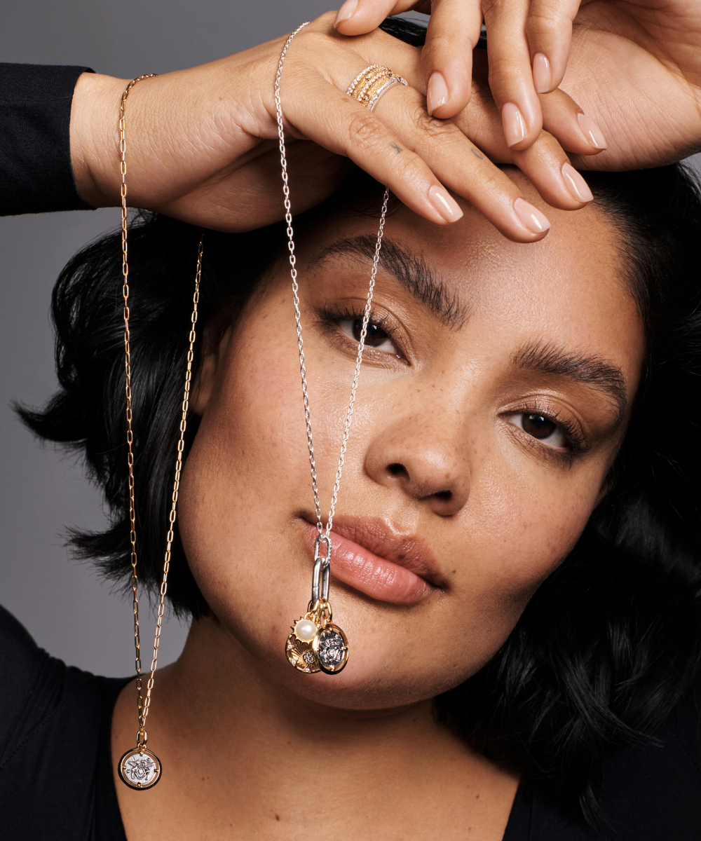 Observe uma mulher segurando colares e usando anéis elegantes.