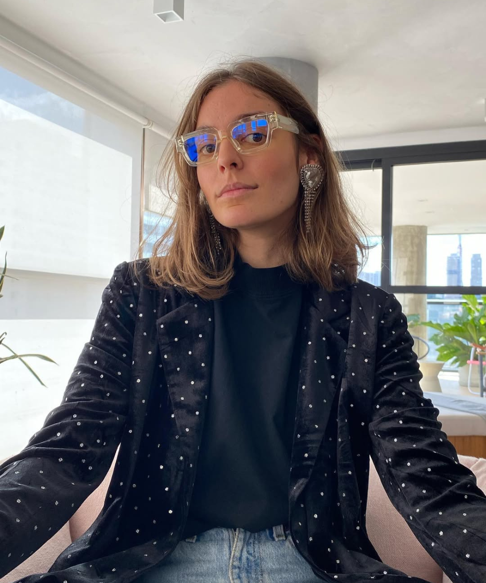 Pessoa com casaco de bolinhas e óculos transparentes. Ideal para tendências discutidas no Iguatemi Talks Fashion.