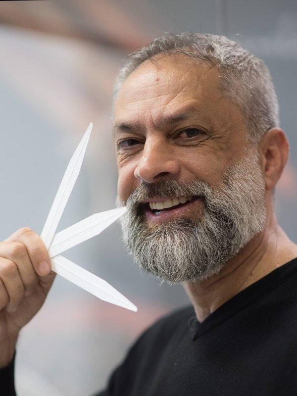 Pessoa sorrindo segura tiras de papel usadas para testar tendências de fragrâncias.