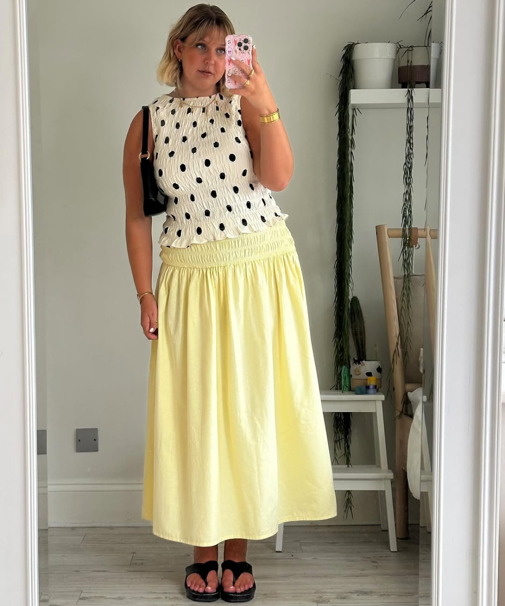 Pessoa vestindo saia amarela e blusa de bolinhas, estilo ideal para usar poá na primavera.
