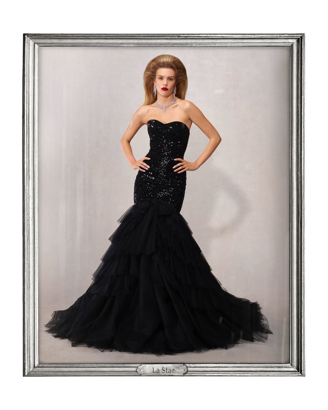 Modelo em vestido preto longo e elegante, posando em moldura prateada. Gucci de Demna