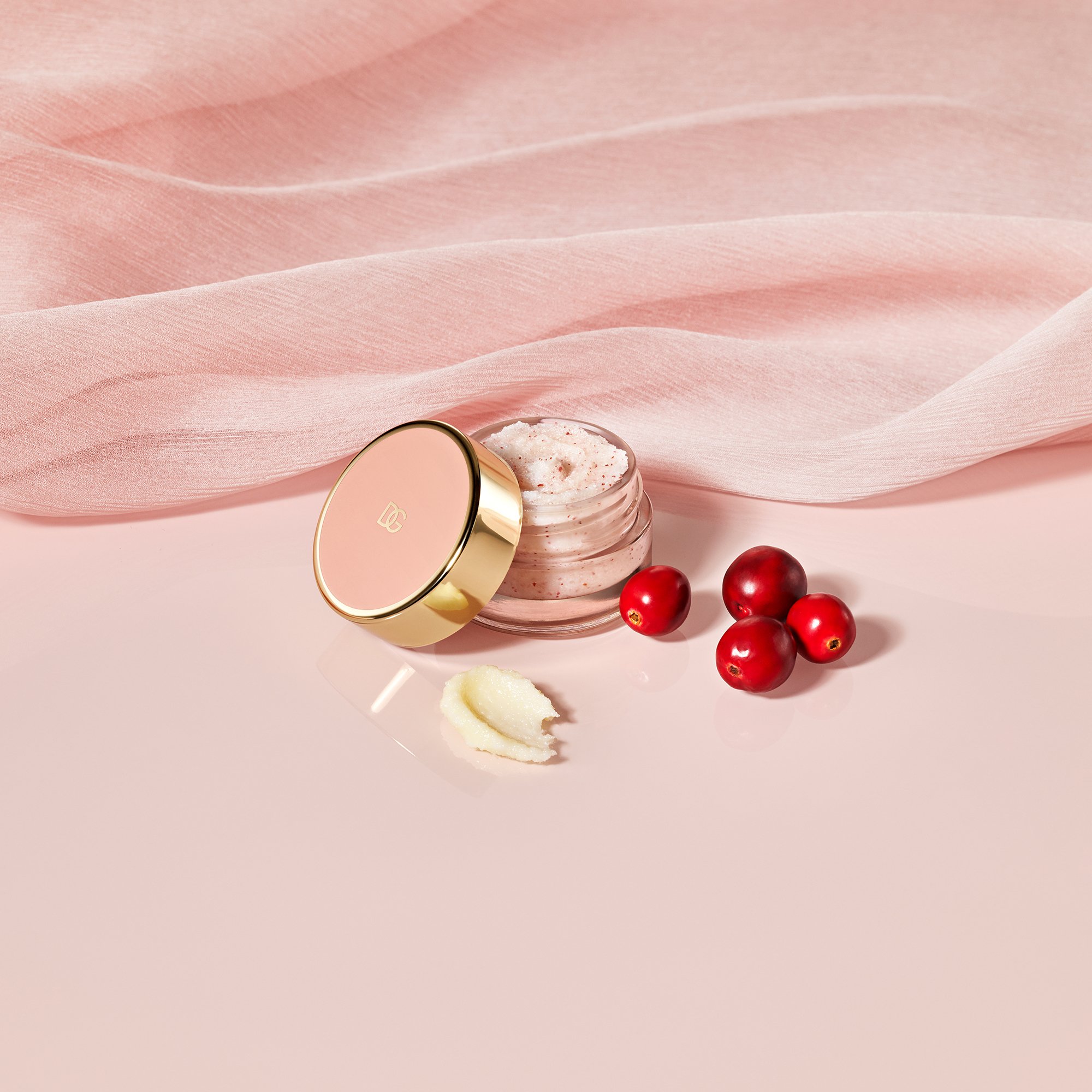 Pote de esfoliante rosa da Fresh Skin Collection com frutos vermelhos ao lado, sobre fundo suave.