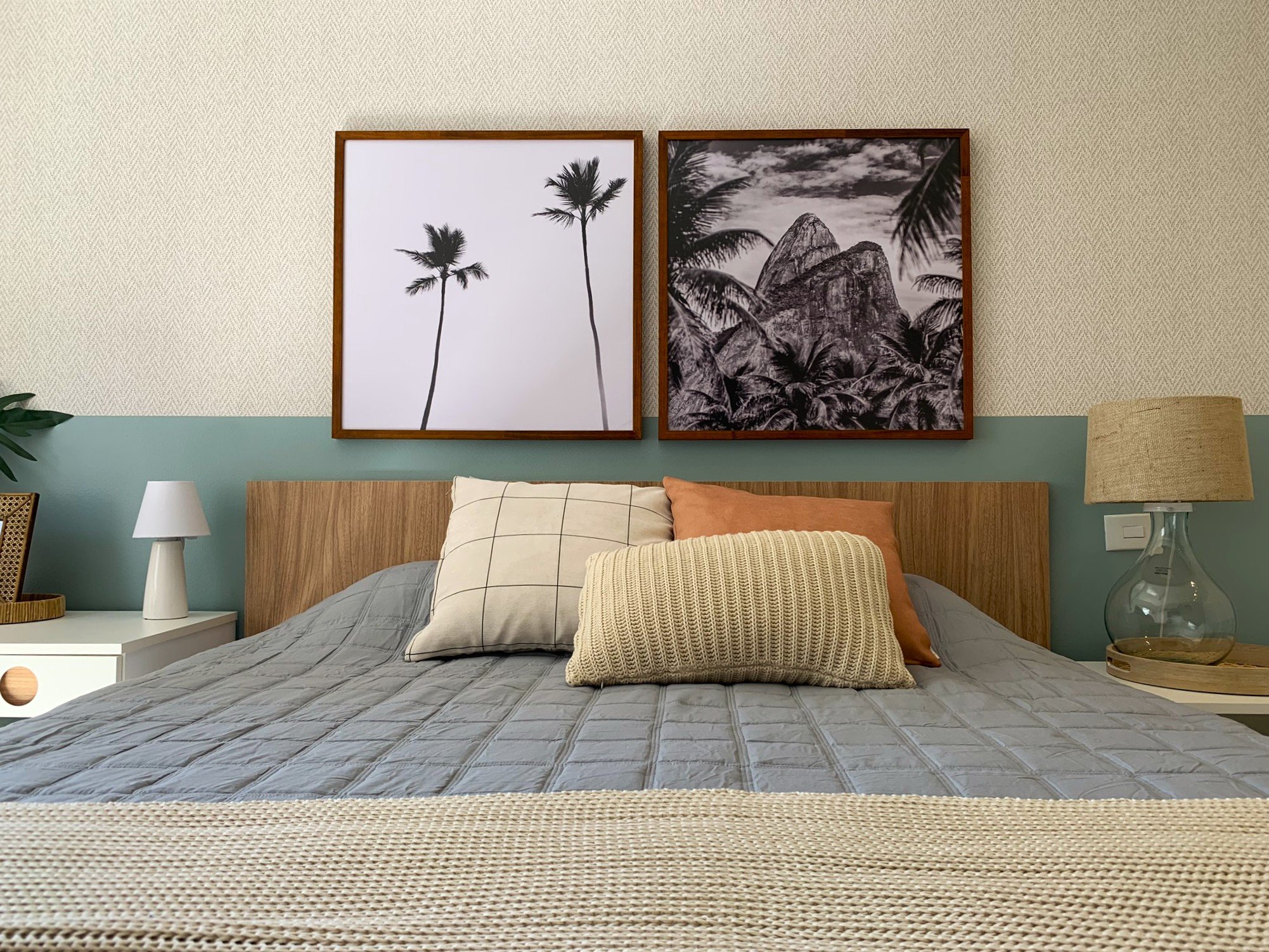 Quarto aconchegante com cama coberta, almofadas, abajures e quadros de paisagens, oferecendo dicas de decoração.