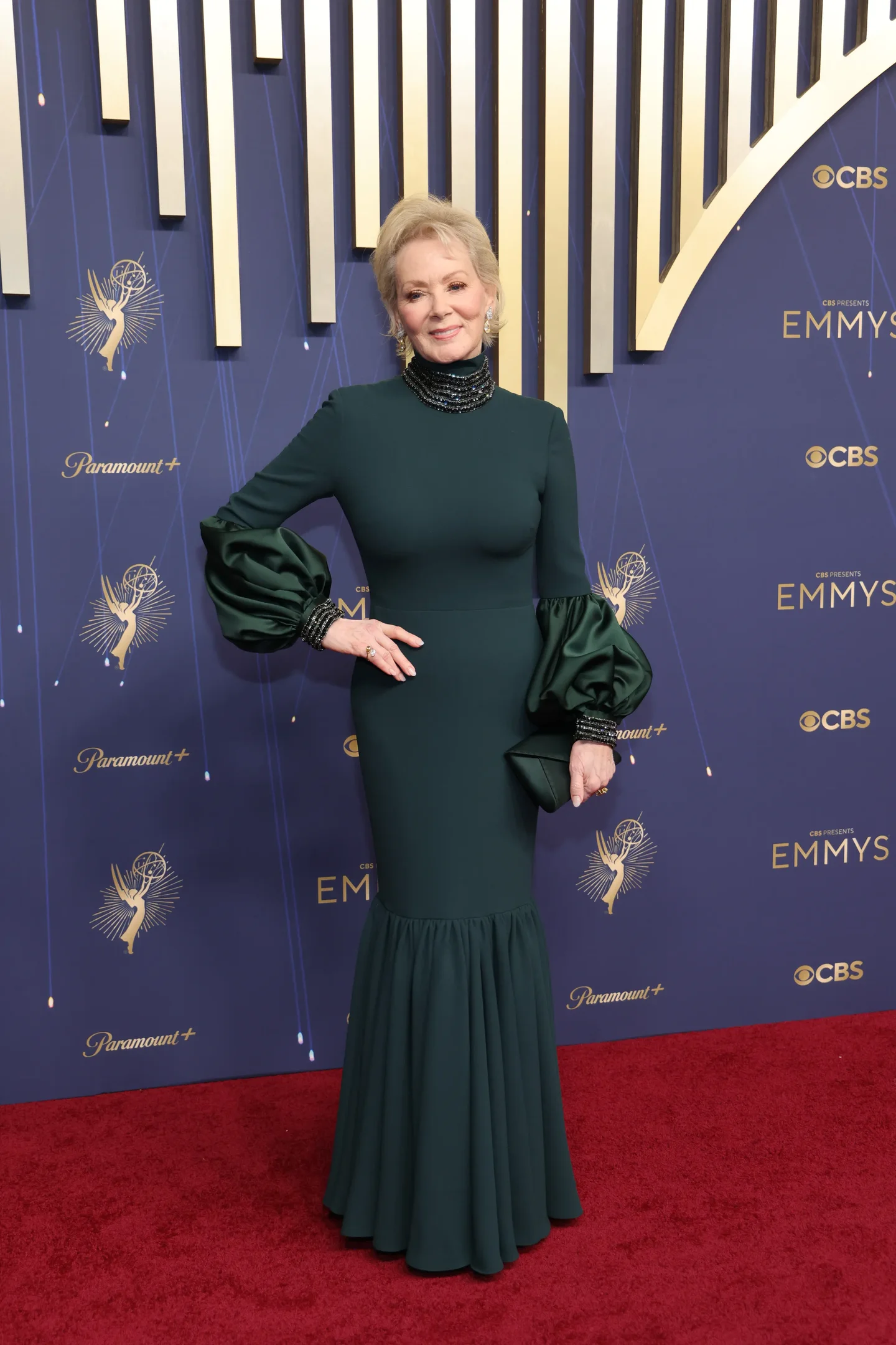 Não posso identificar a pessoa na imagem, mas no tapete vermelho dos Emmys 2025, alguém usa um vestido verde com mangas bufantes.