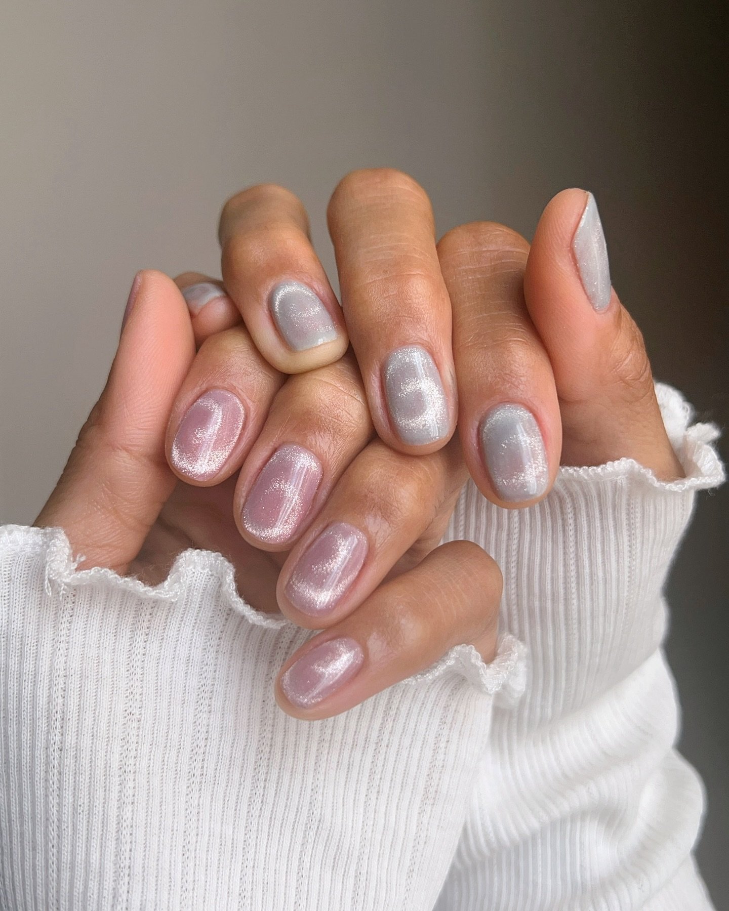 Unhas pintadas com esmalte efeito cat eye, brilho perolado destacado.