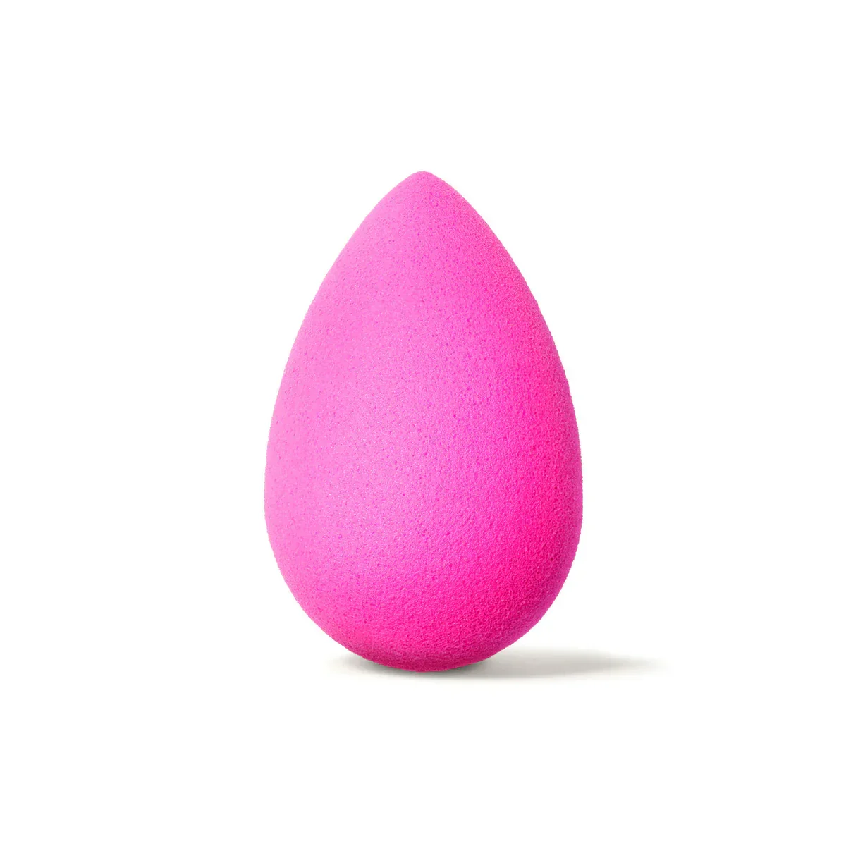 Esponja de maquiagem rosa em formato de gota sobre fundo branco.