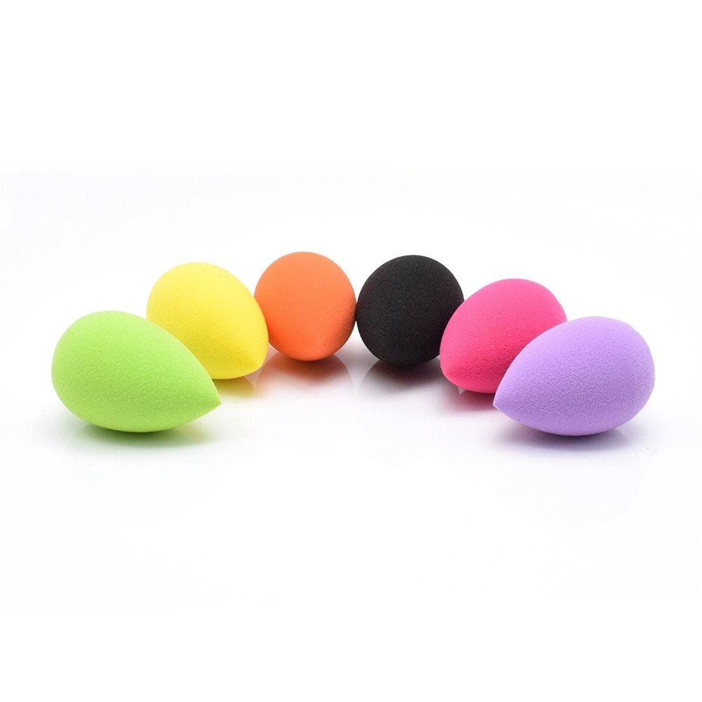 Esponjas de maquiagem coloridas em formato de gota, dispostas em linha sobre superfície branca.