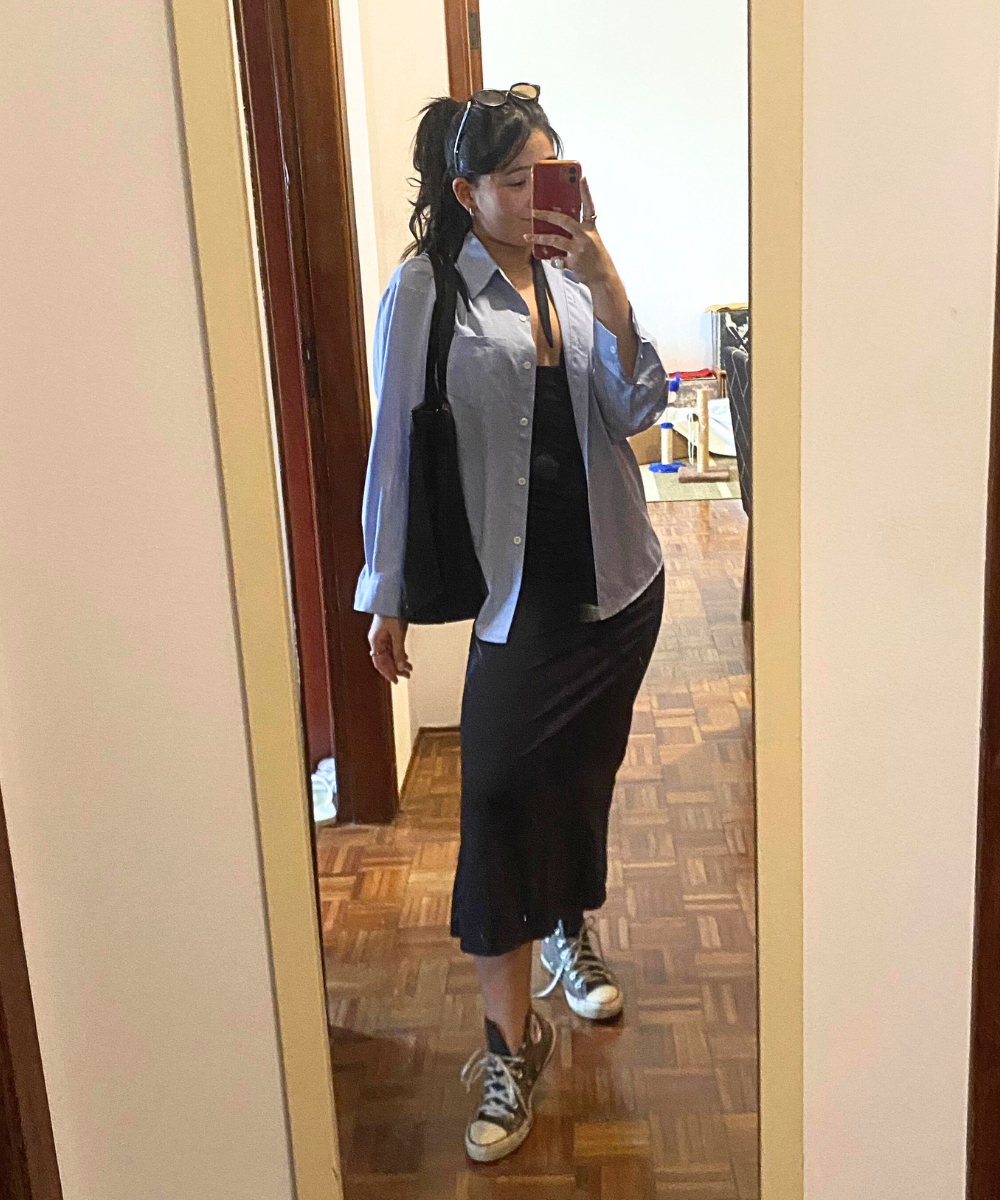Pessoa usando tênis estilo All Star com vestido preto e camisa azul clara.