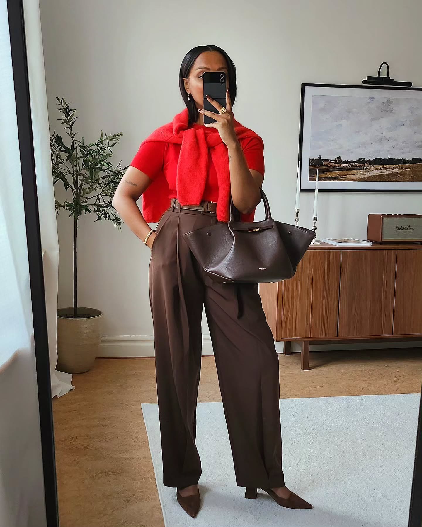 Look profissional com blusa vermelha e calça marrom, incluindo bolsa combinando. Ideal para os melhores looks de trabalho.