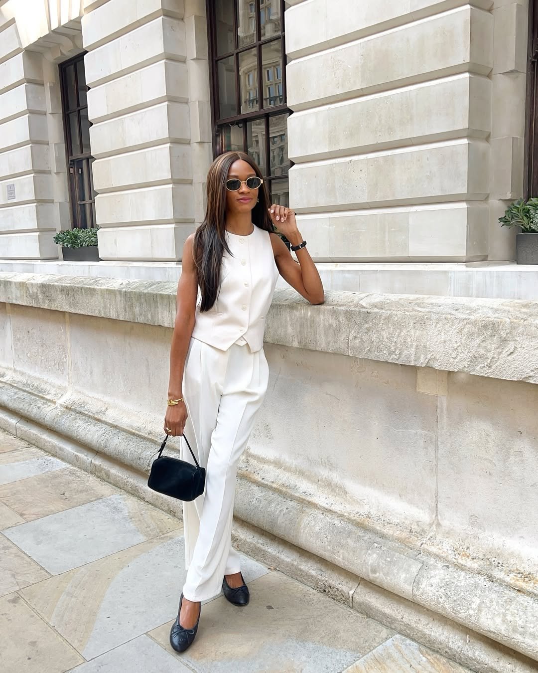 Pessoa com roupa elegante em tons claros, ideal para trabalho, em local urbano.