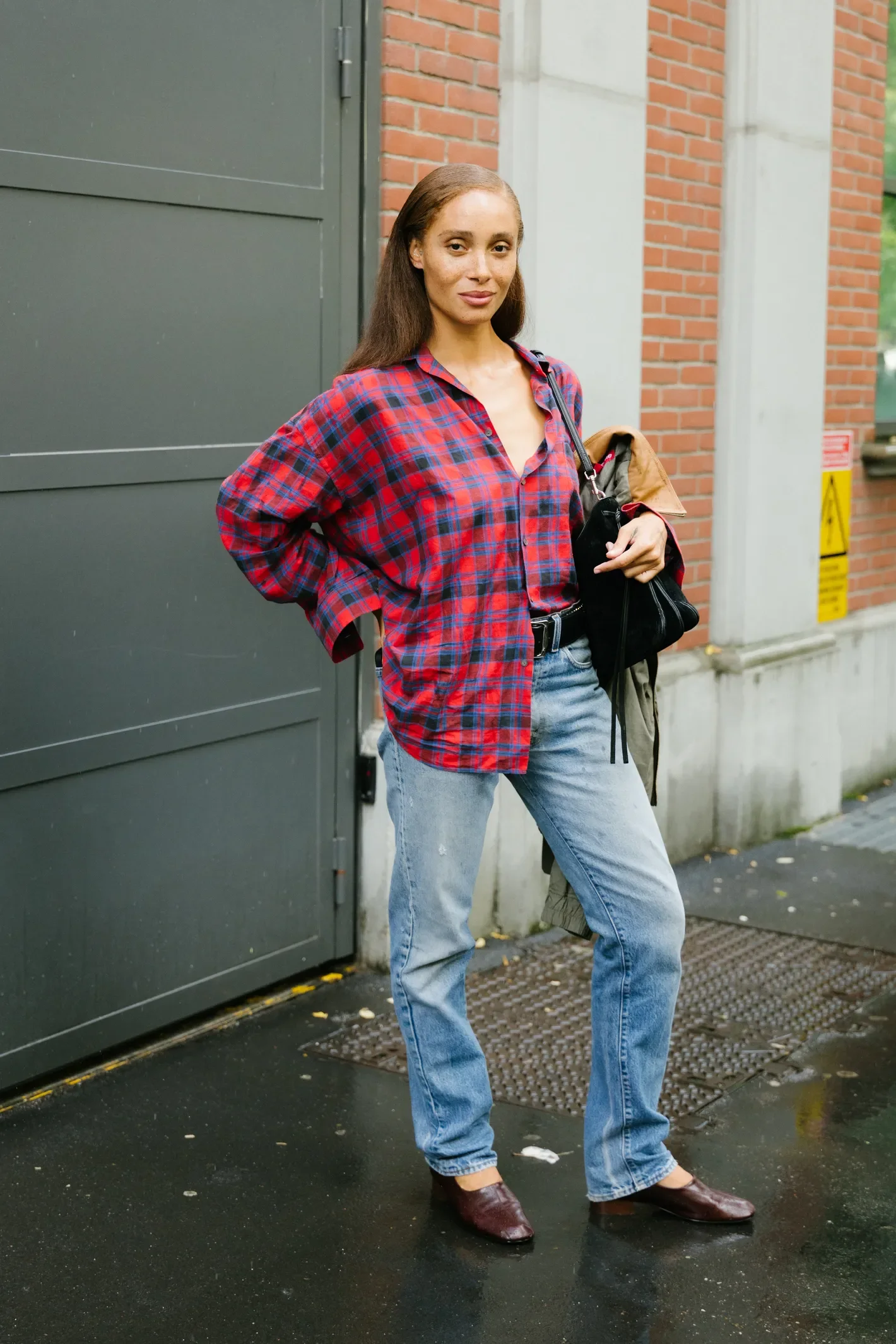 Pessoa em look casual, combinando camisa xadrez e jeans, ilustra truques de estilo fáceis para o dia a dia.