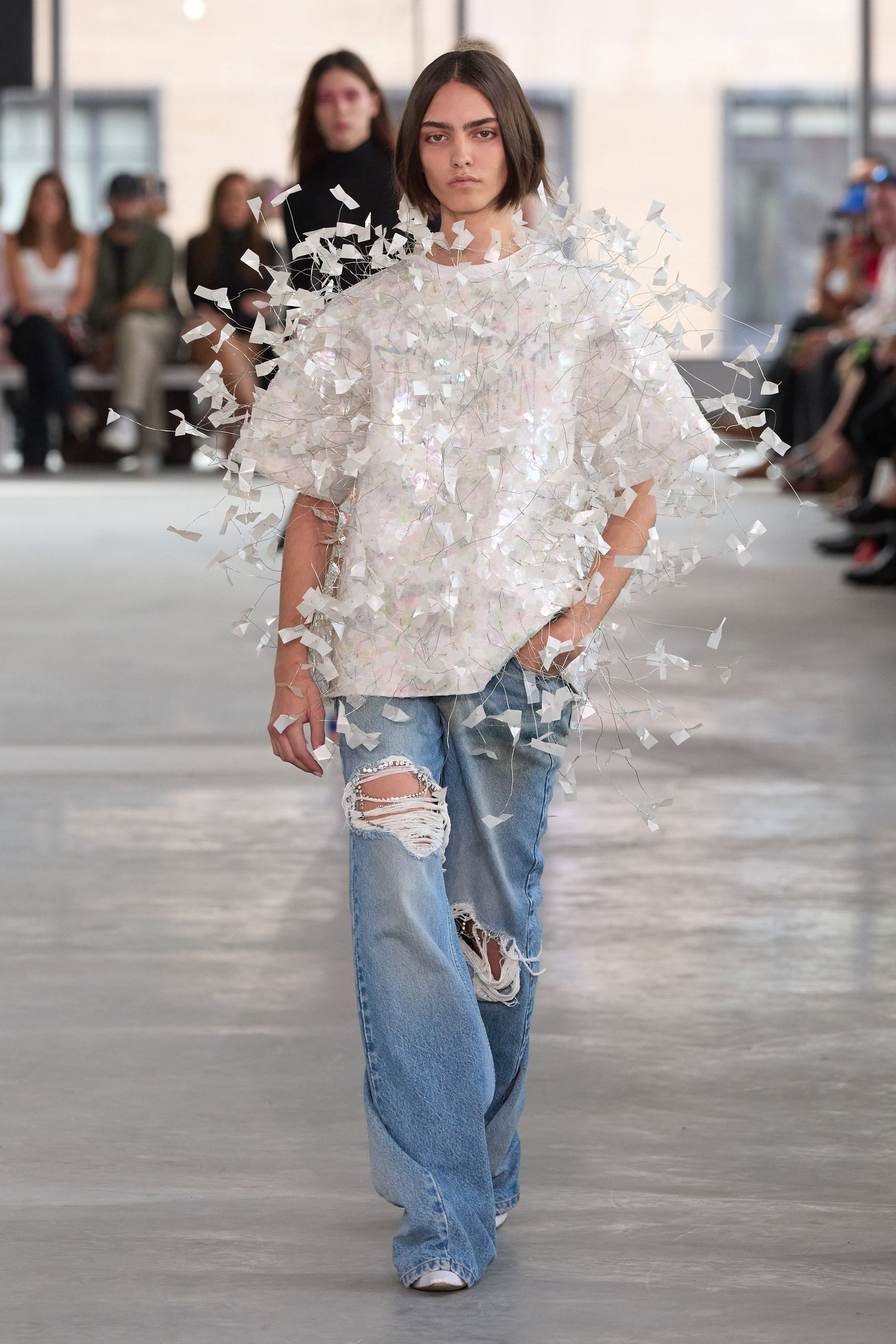 Modelo desfila com blusa texturizada e jeans rasgados na New York Fashion Week SS26.