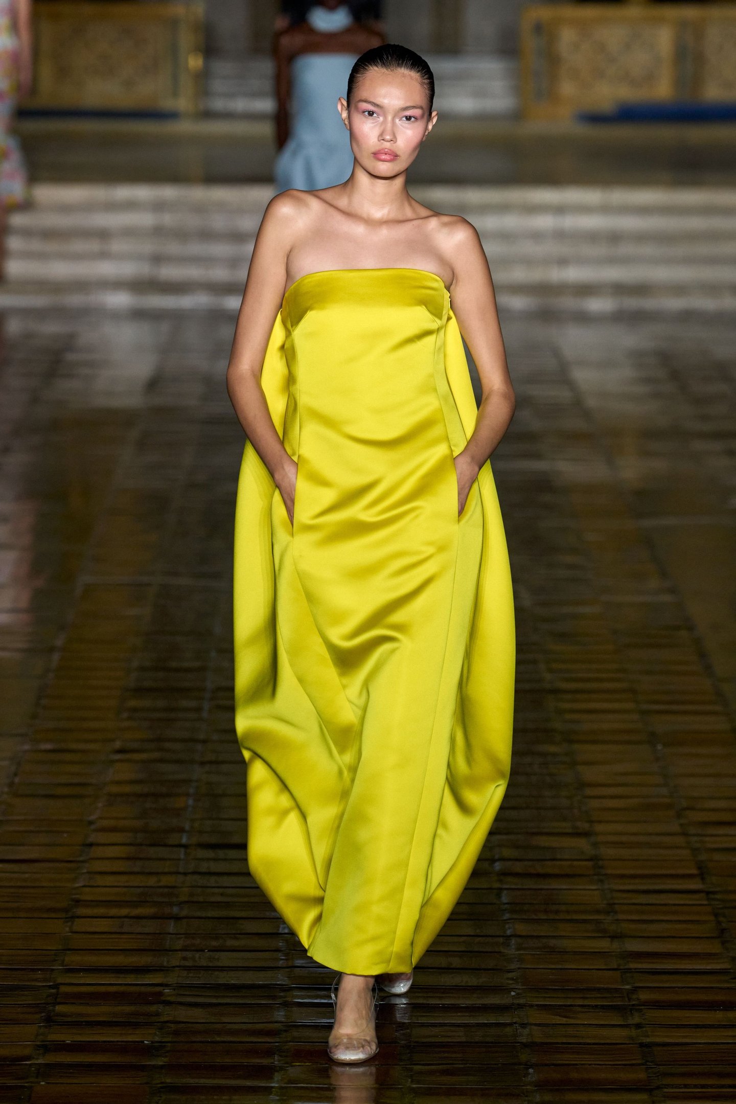 Modelo vestindo um vestido amarelo vibrante durante desfile da New York Fashion Week SS26.