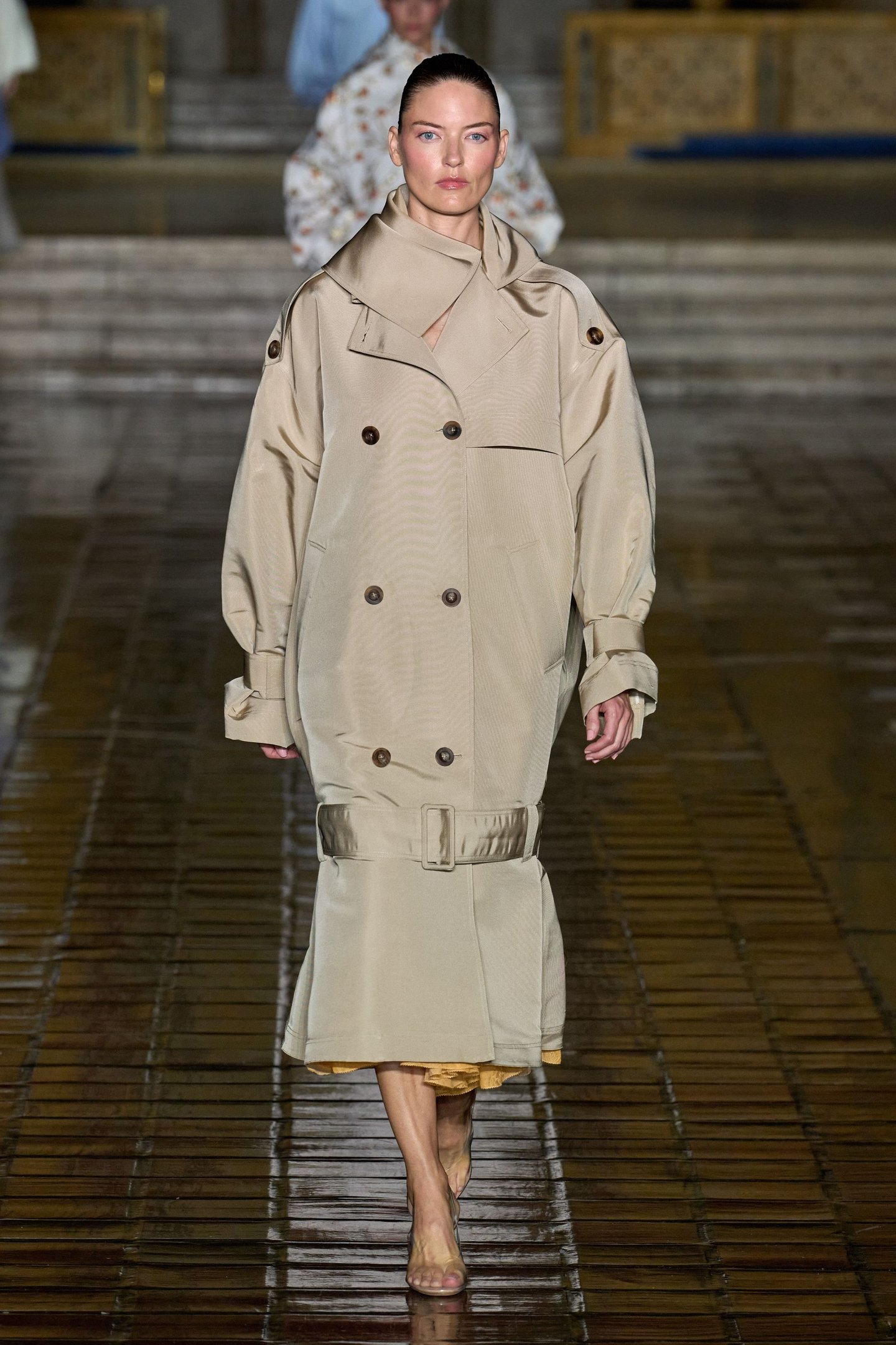 Modelo desfilando com casaco bege oversize na New York Fashion Week SS26.