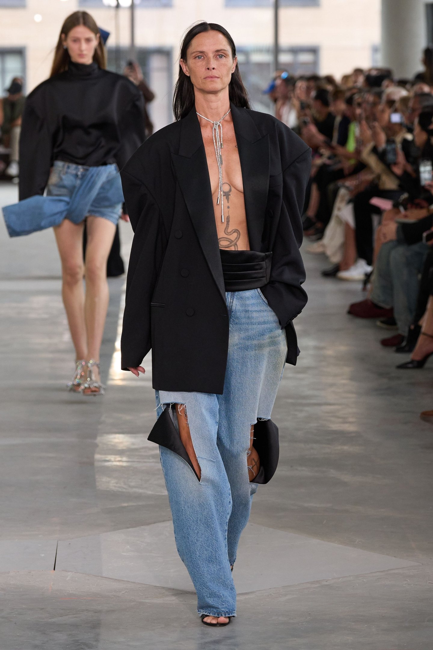Modelos desfilam com jaquetas pretas largas e jeans na New York Fashion Week SS26.