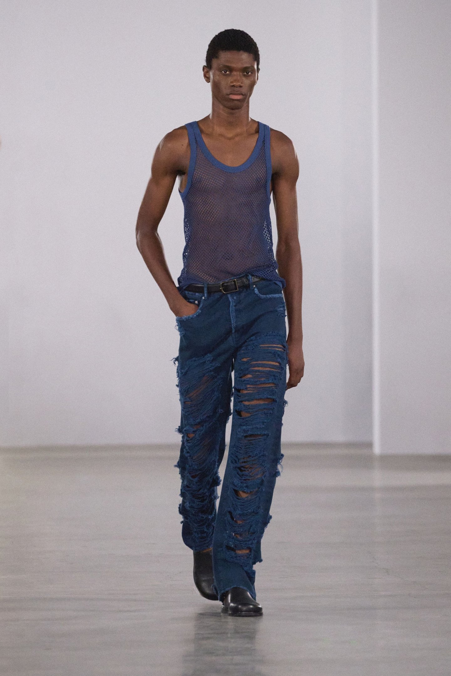 Desfile na New York Fashion Week SS26, modelo veste regata azul transparente e calça jeans rasgada.