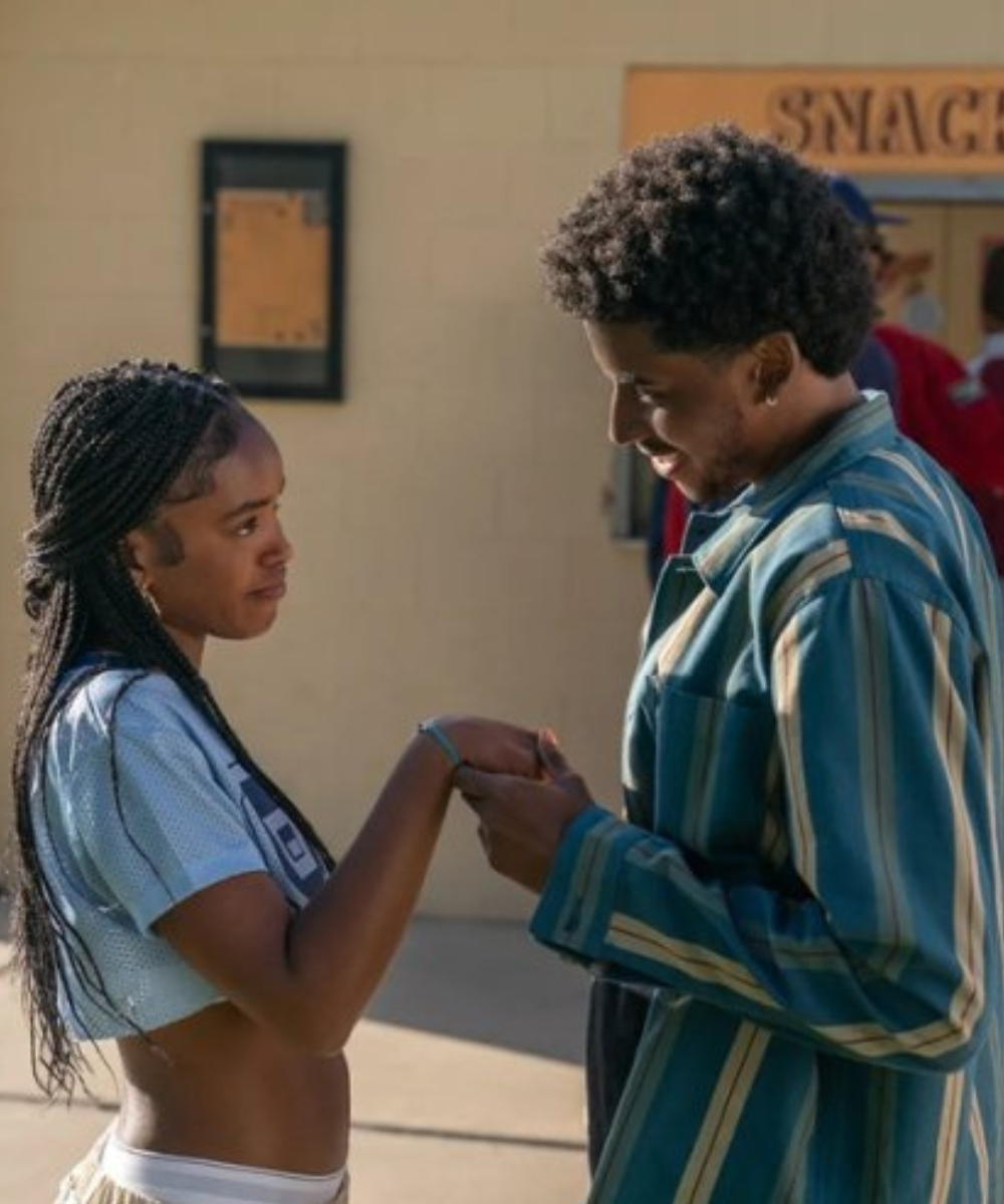 Duas pessoas trocam olhares e seguram as mãos, remetendo a