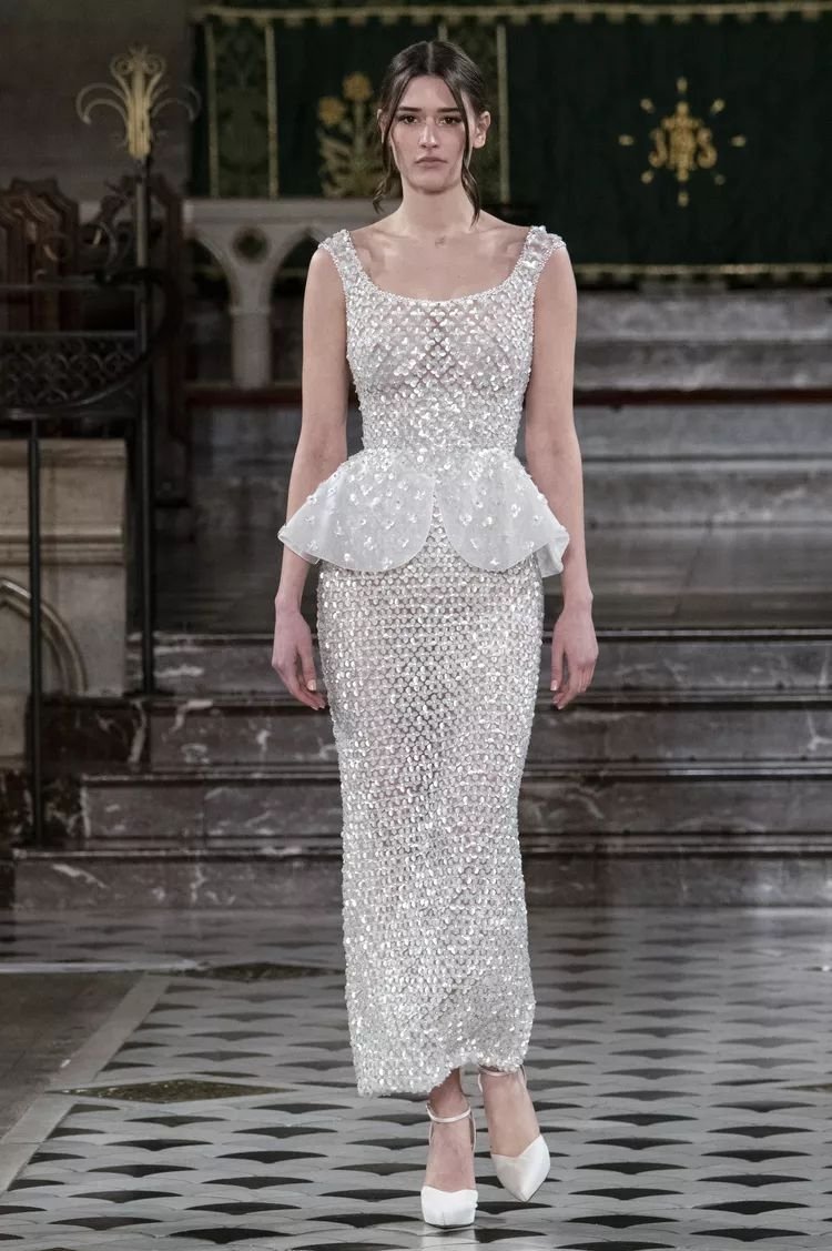 Vestido cintilante com detalhe peplum, usado por uma modelo em um ambiente elegante.