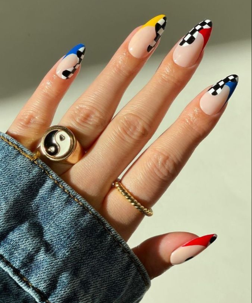Nail arts de F1, exibindo cores vibrantes e padrões quadriculados.