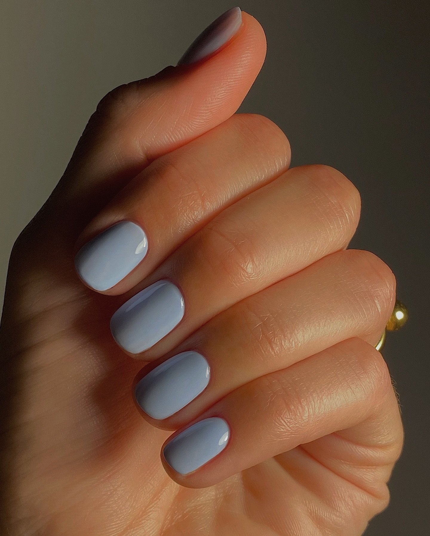 Unhas curtas pintadas de azul claro, estilo primavera.