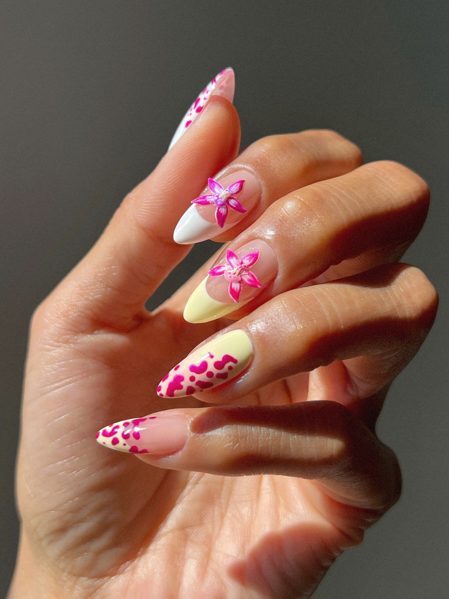 Unhas para primavera decoradas com flores e manchas rosas, ideais para primavera.