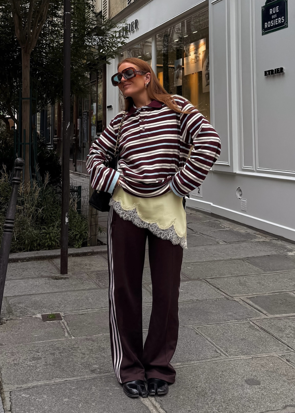A blusa de cetim feminina é uma peça versátil e elegante, ideal para compor looks sofisticados. Na imagem, a combinação de uma blusa de cetim com detalhes em renda sob uma camiseta listrada cria um contraste interessante.