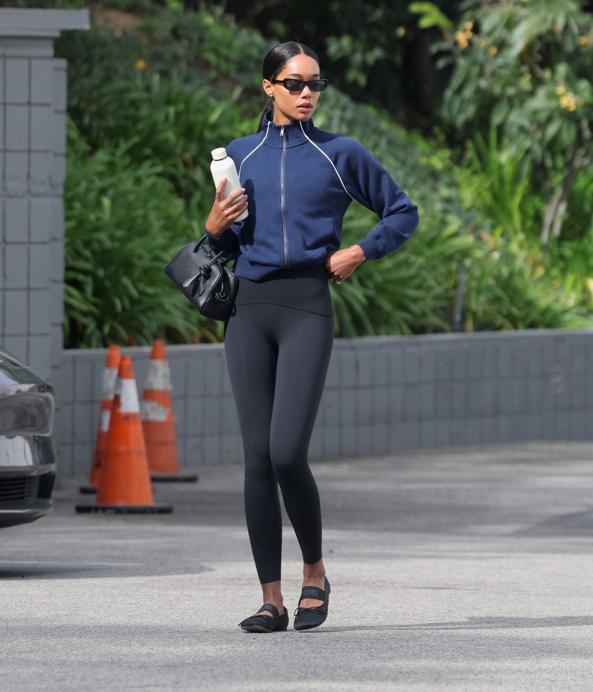 Looks com calça legging se destaca pela combinação de conforto e estilo. A modelo usa uma calça legging preta, que valoriza a silhueta, acompanhada de um moletom azul com detalhes em branco.